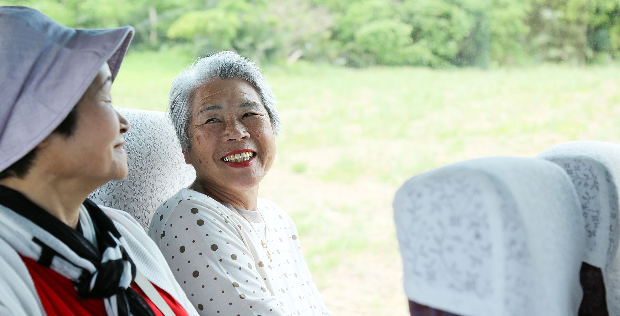 A pair of older women riding a train